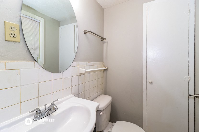 a bathroom with a sink and a toilet and a mirror