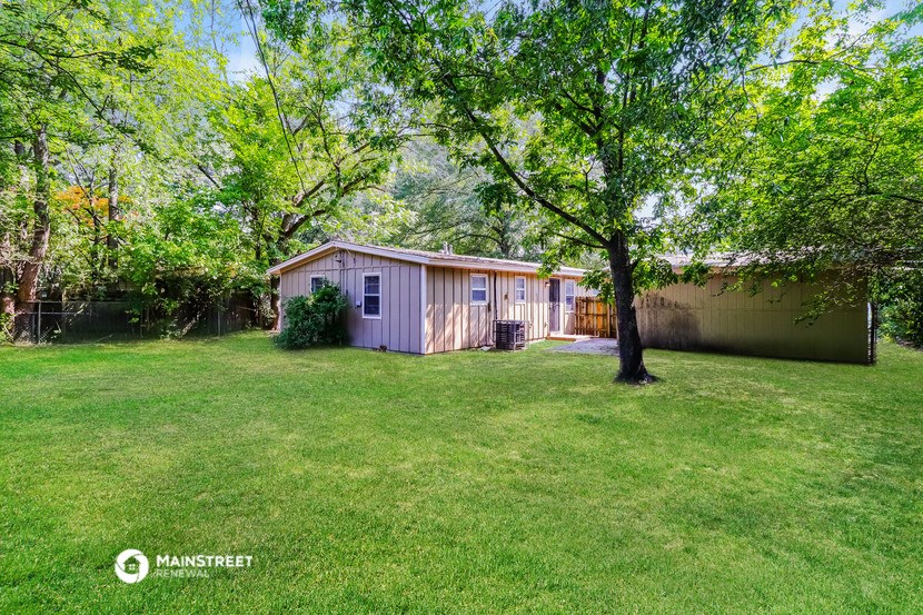 a small pink house with a yard and a tree
