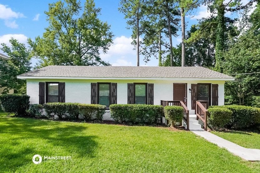a small white house with black windows and a lawn