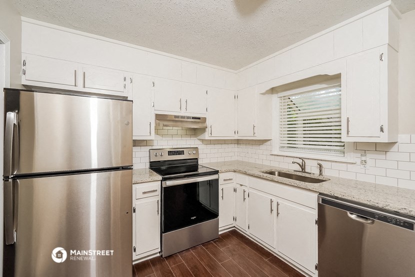 a kitchen with white cabinets and stainless steel appliances