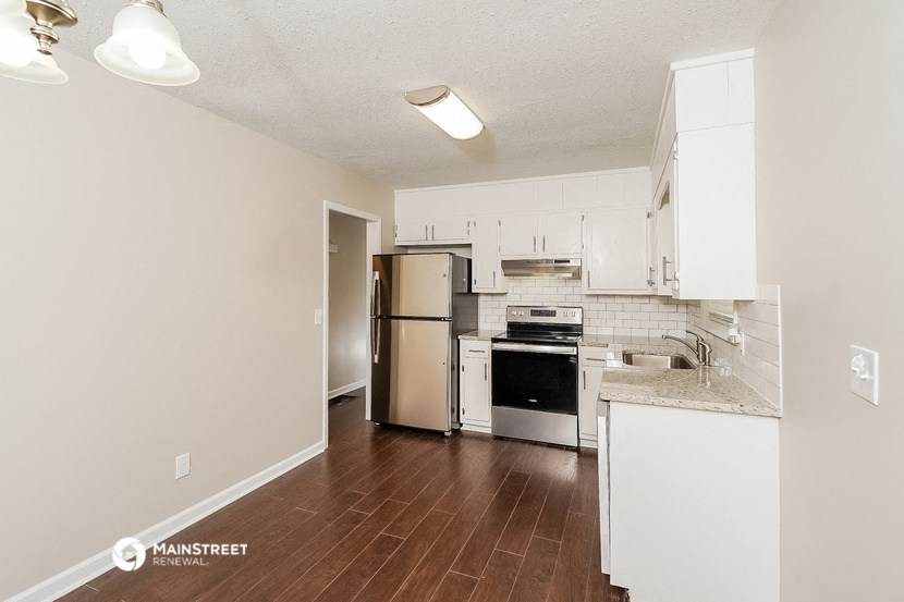 a renovated kitchen with white cabinets and stainless steel appliances