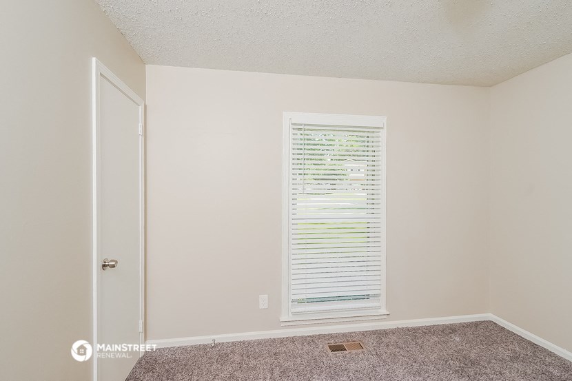 a living room with a window and a door to a closet