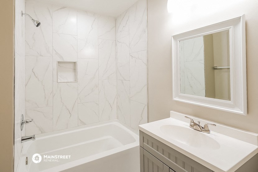 a bathroom with a sink and a tub and a mirror