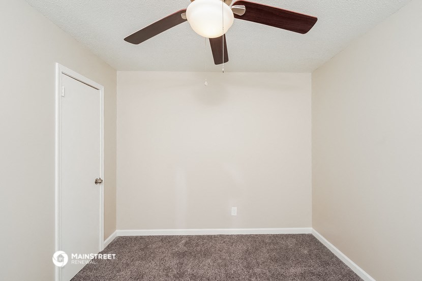 a bedroom with a ceiling fan and carpet