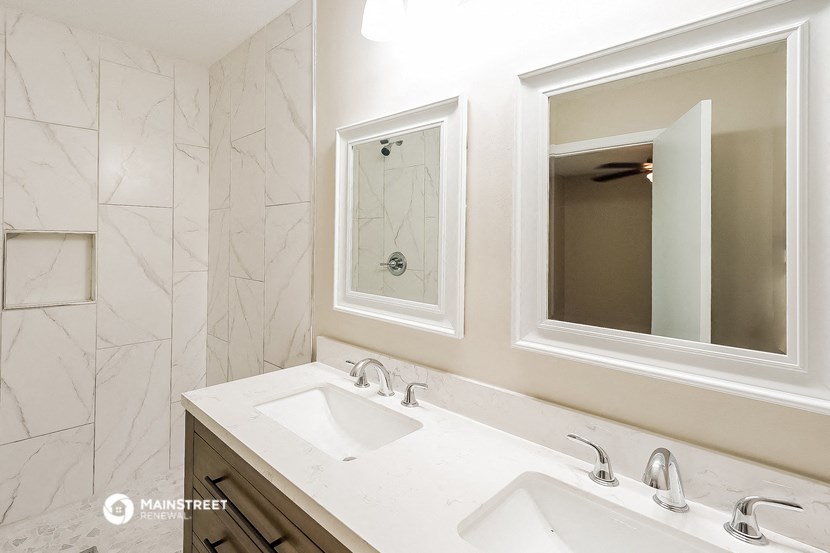 a bathroom with two sinks and two mirrors