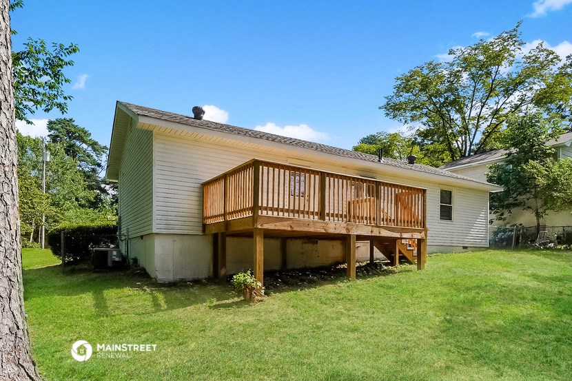 a white house with a porch and a wooden deck