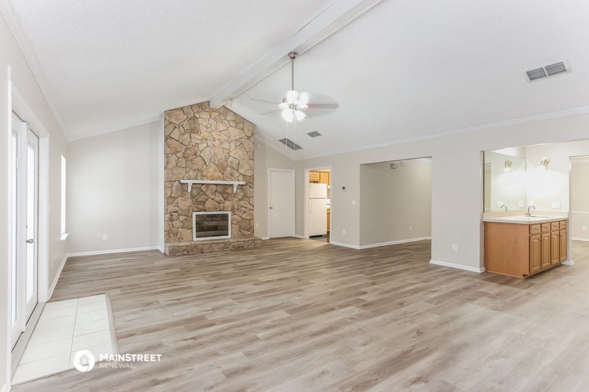 a living room with a fireplace and a wooden floor