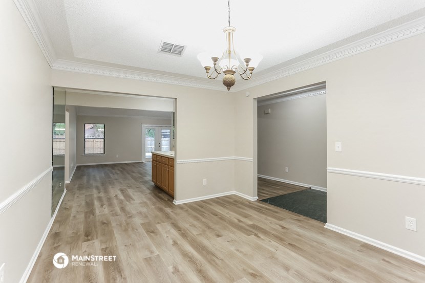 an empty living room and dining room with wood flooring