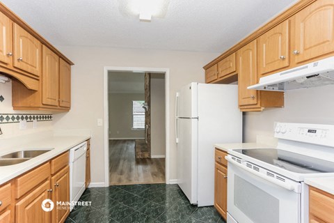 a kitchen with wood cabinets and white appliances and a refrigerator