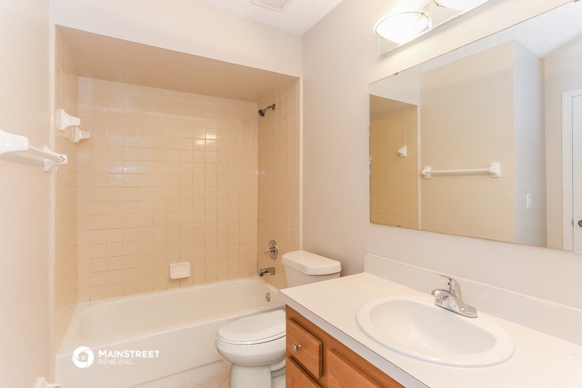 a bathroom with a sink toilet and tub and a mirror