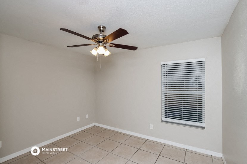 the living room has a ceiling fan and a window