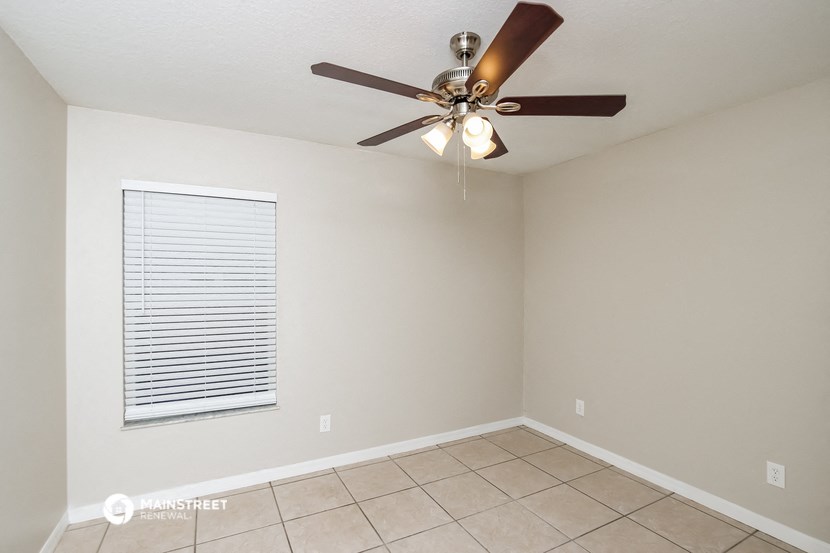 the living room has a ceiling fan and a tiled floor