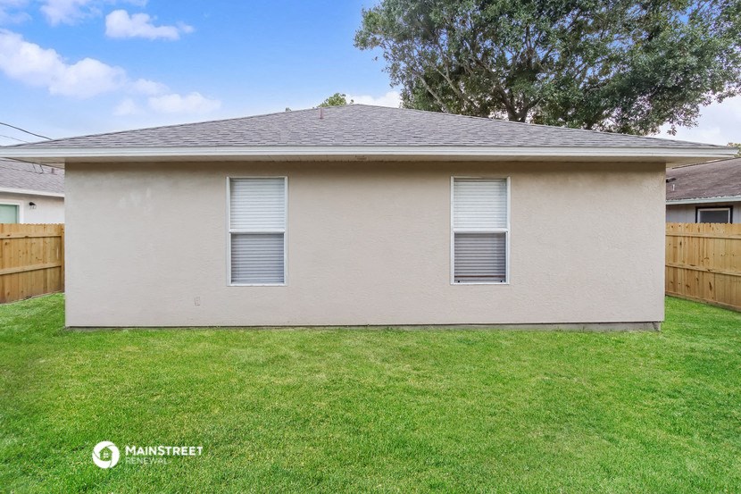 the backyard of a home with a lawn and a fence