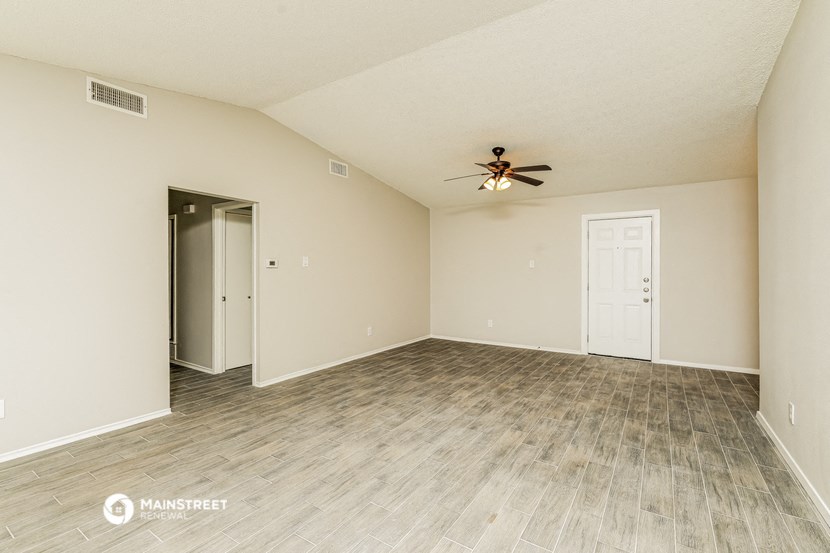 the spacious living room with ceiling fan and vinyl flooring