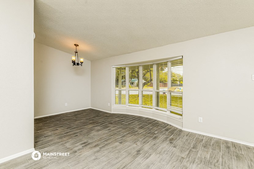 the living room with wood floors and a large window