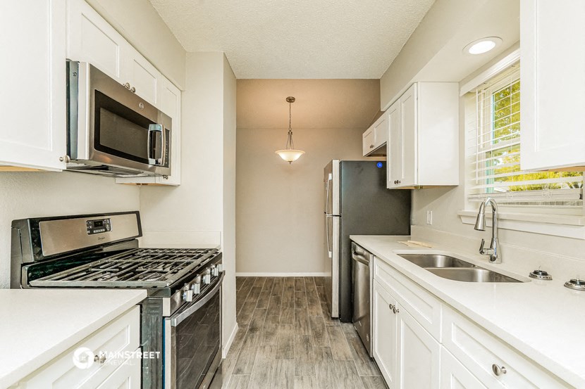 a kitchen with stainless steel appliances and white cabinets