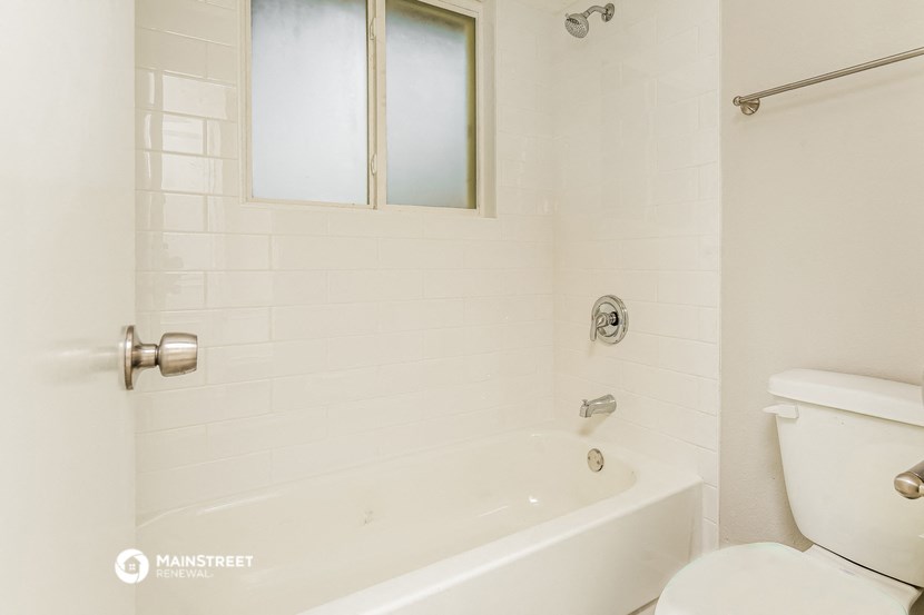 a white bathroom with a tub and a toilet