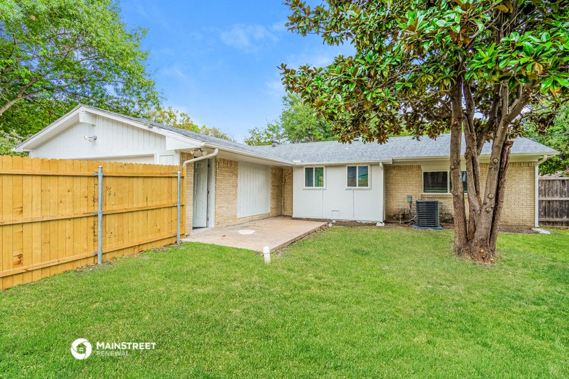 a white house with a yard and a wooden fence