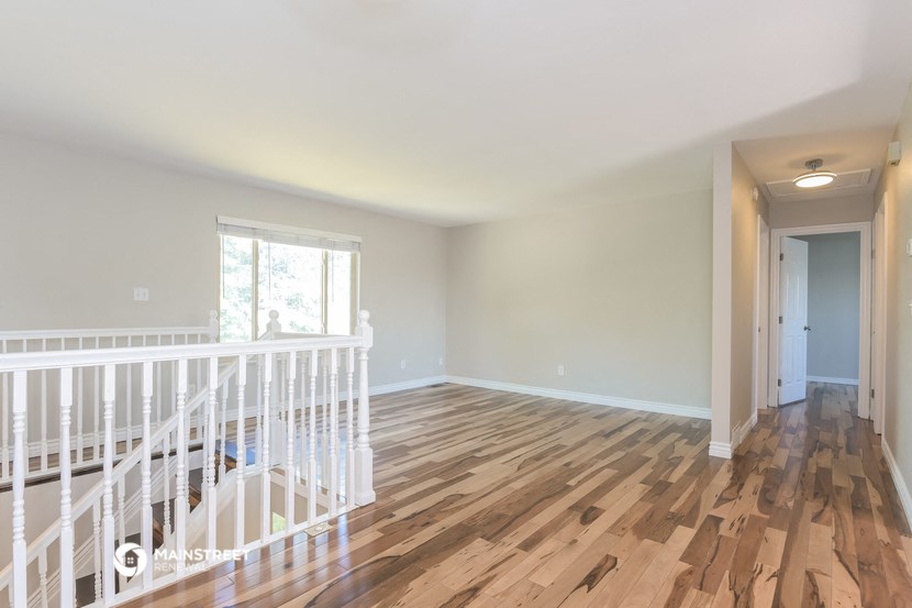 the living room and dining room of a house with wood flooring