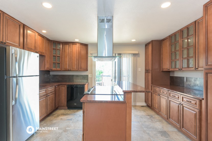 a large kitchen with wooden cabinets and stainless steel appliances