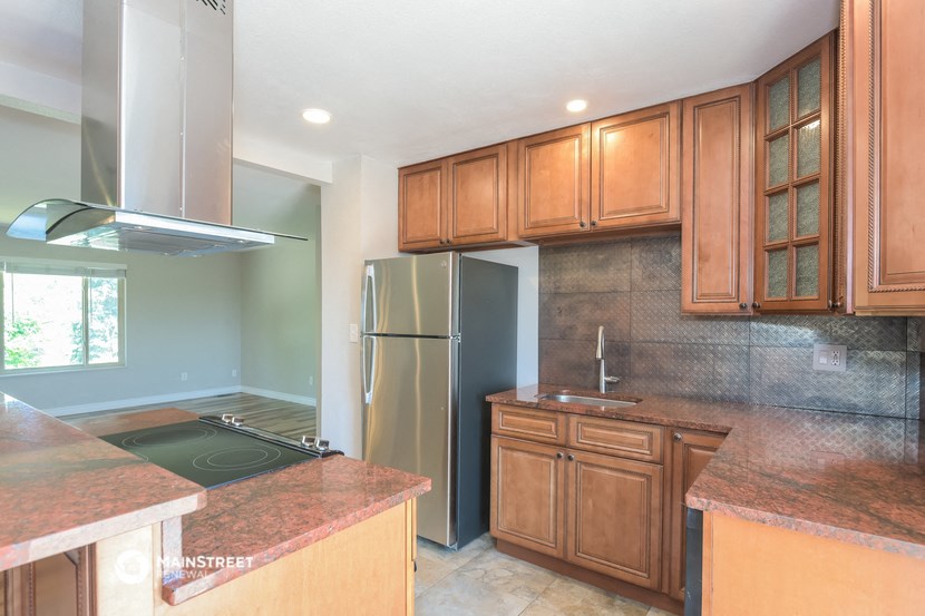 a kitchen with wooden cabinets and a stainless steel refrigerator