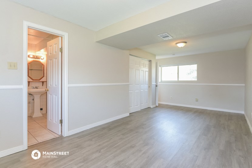 an empty living room with white walls and wood flooring