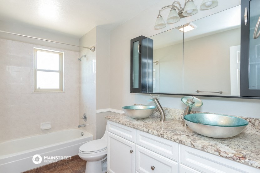a bathroom with two sinks and a tub and a mirror