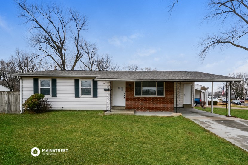 the front of a white house with green shutters and a lawn