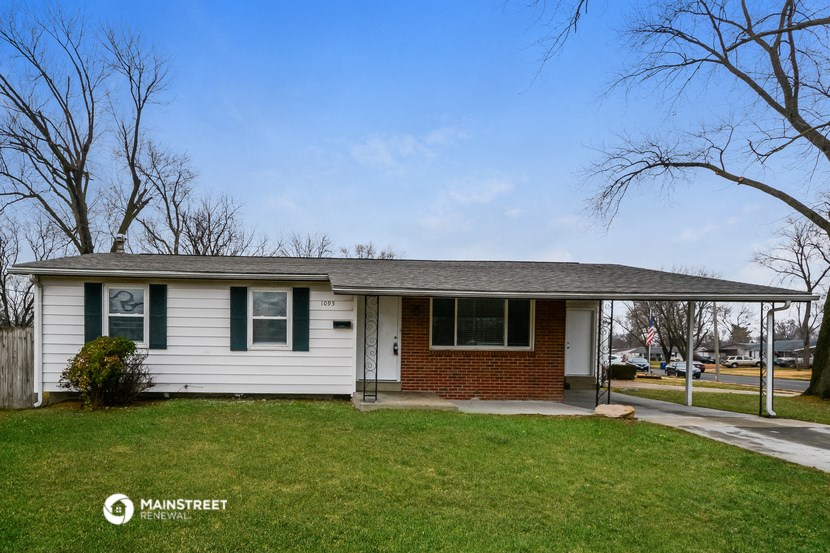 a small white house with green shutters and a lawn