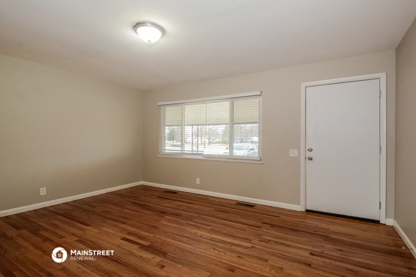 the interior of an empty room with wooden floors and a window
