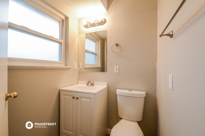 a bathroom with a toilet and a sink and a window