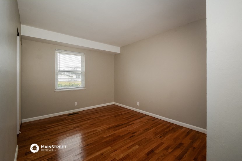 the interior of an empty room with wooden floors and a window