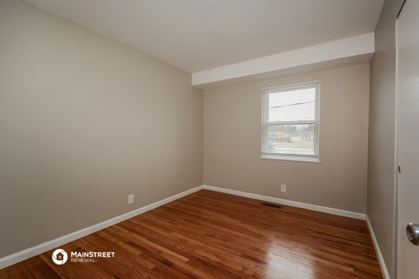 the interior of an empty room with wooden floors and a window