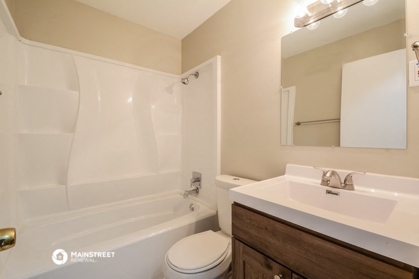 a bathroom with a sink toilet and tub and a mirror