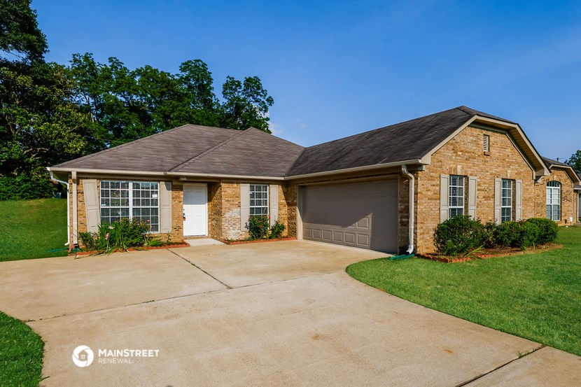 a brick house with a driveway and a garage door