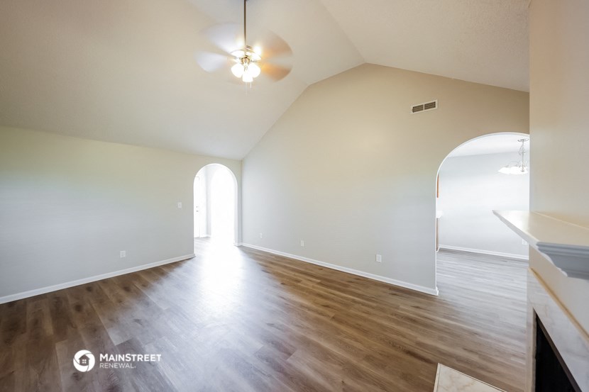 the living room and dining room with hardwood flooring and white walls