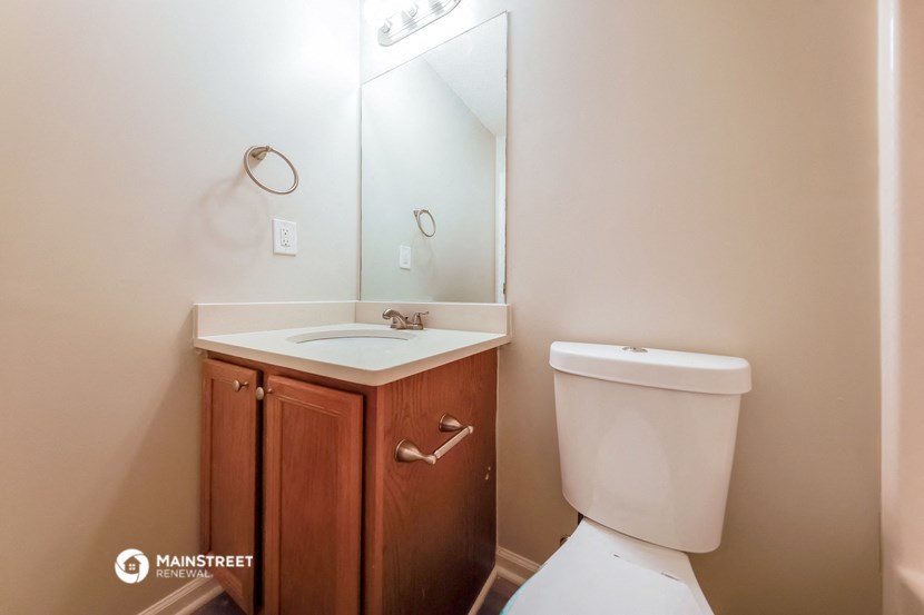 a bathroom with a toilet and a sink and a mirror