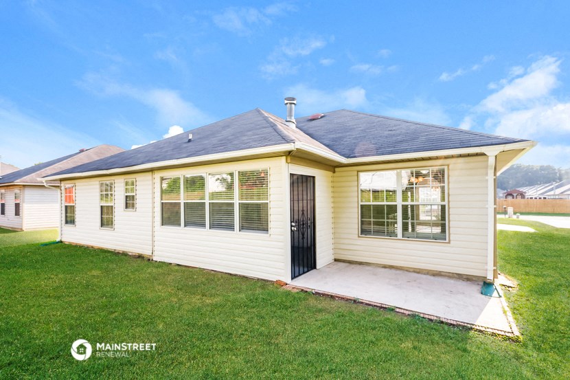 a small white house with a porch and a lawn