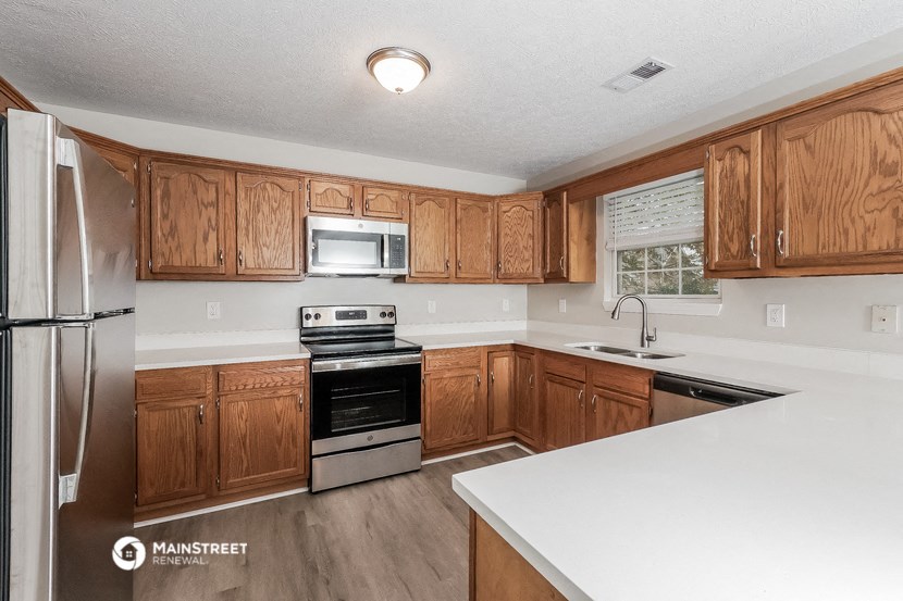 a kitchen with wooden cabinets and a white counter top