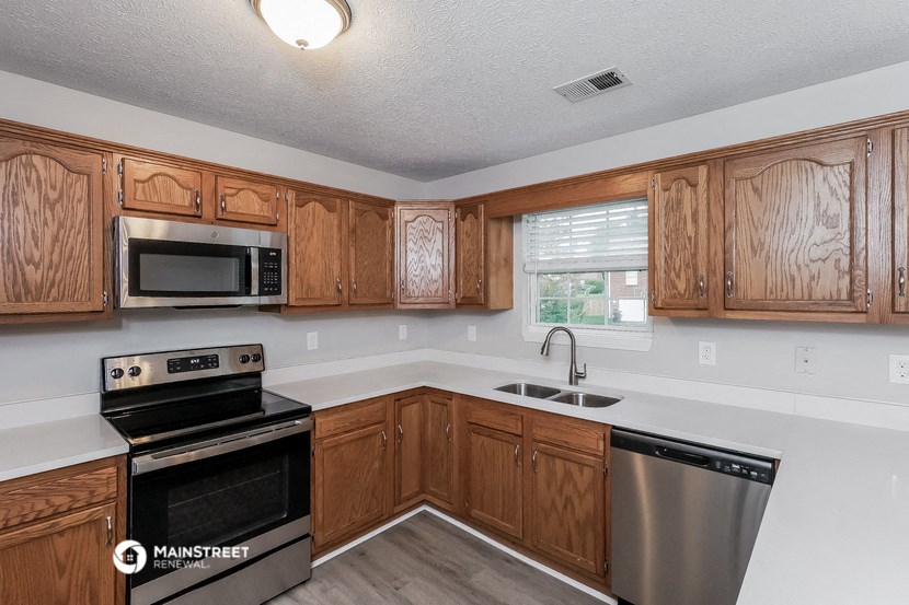 a kitchen with wooden cabinets and stainless steel appliances