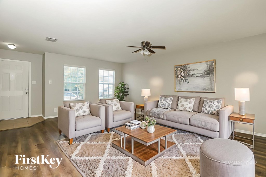 A well-lit living room with a couch, chairs, and a coffee table.