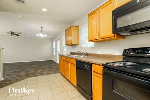 A kitchen with wooden cabinets and black appliances.