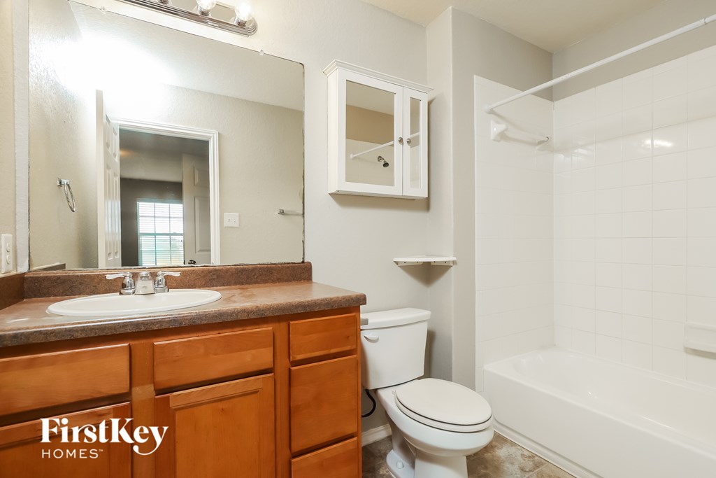 A bathroom with a sink, toilet, and bathtub.