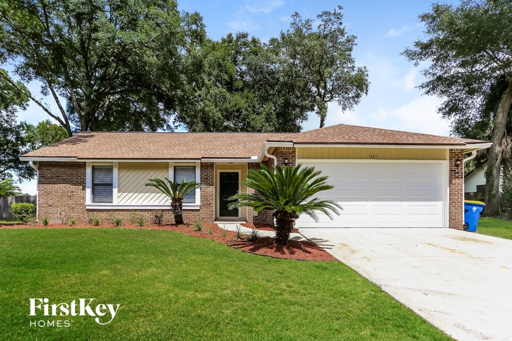 a home with a white garage door and a lawn