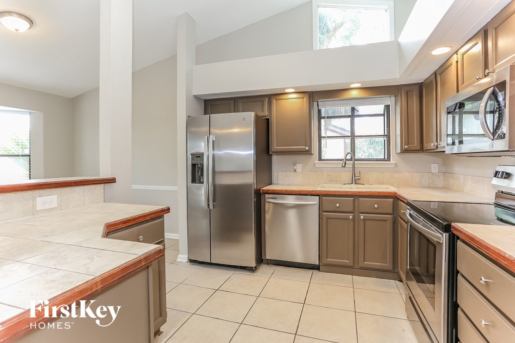 a kitchen with wooden cabinets and stainless steel appliances