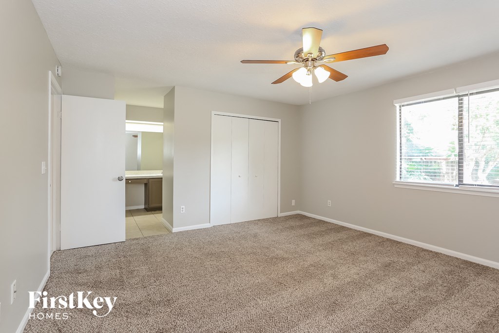 the living room of an empty house with a ceiling fan