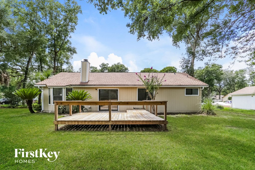 a backyard with a deck and a house