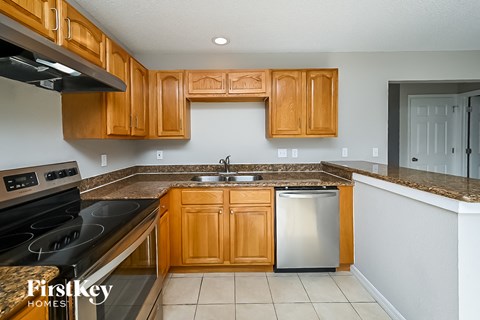 A kitchen with wooden cabinets and a stainless steel dishwasher.