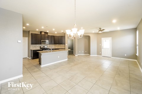 an open kitchen and living room with a large tile flooring