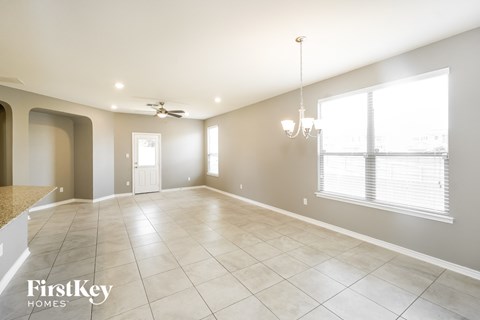 an empty living room with a ceiling fan and a large window